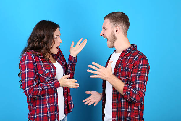 istock Young couple arguing on blue background 2210080583