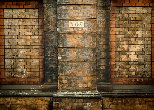 istock Old outdoor brick wall with no littering sign 2210081597