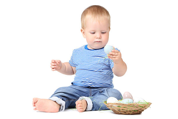 istock Baby boy with easter eggs in basket isolated on white background 2210083210
