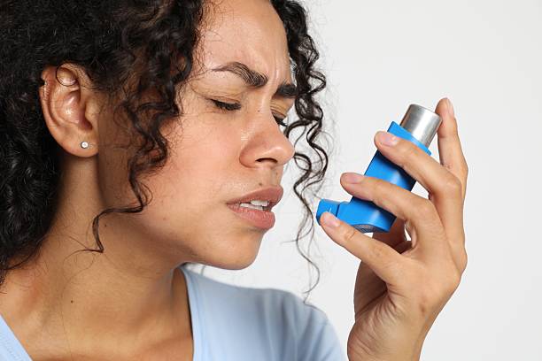istock Young woman using asthma inhaler on white background, closeup 2210085413