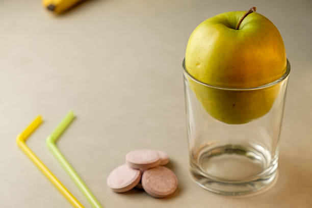 istock Balancing green apple and colorful straws on a casual kitchen counter 2210085779