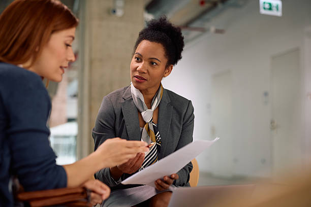 istock Black insurance agent and her client analyzing financial reports during a meeting in the office. 2210085940