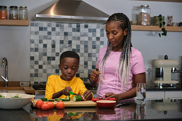 istock Mother and child preparing vegetables together in a modern kitchen 2210087357