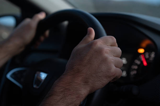 istock Close up of man's hands driving car 2210087519