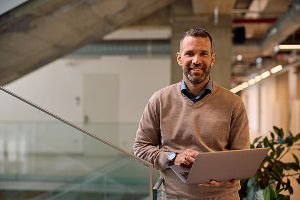 istock Happy entrepreneur using laptop while working in the office and looking at camera. 2210091126