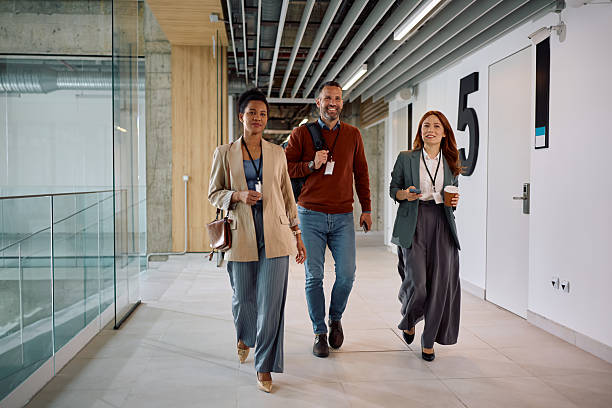 istock Happy business team walking through office hallway. 2210091427