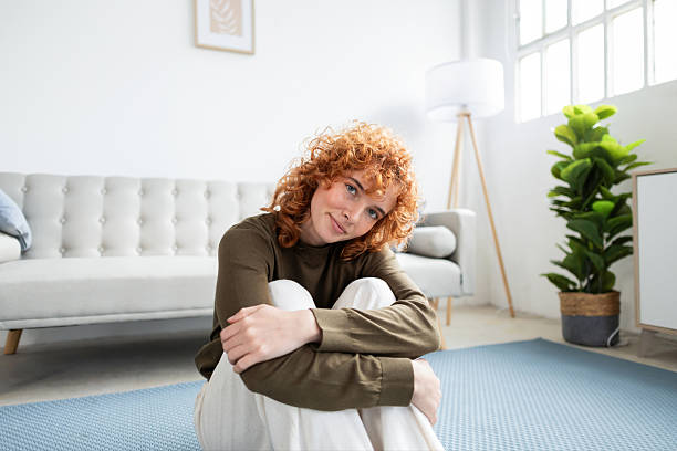 Young woman relaxing at home sitting on carpet