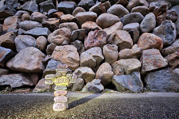Cross made up of stones with the names of Jesus Christ printed on them.