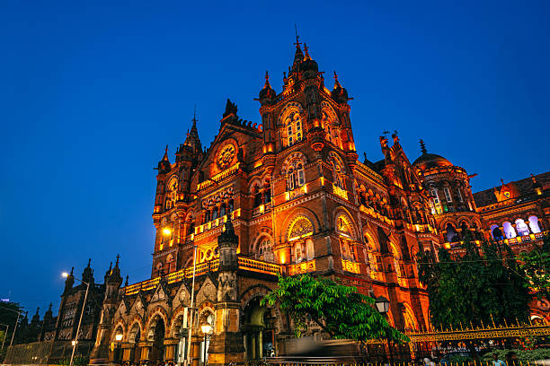 Historic Chhatrapati Shivaji Maharaj Terminus, a UNESCO site in Mumbai with stunning illuminated Gothic-style architecture captured against a clear evening sky.