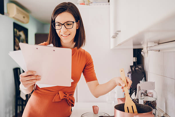 istock The woman professor looking at the students' work while cooking meal 2210100215
