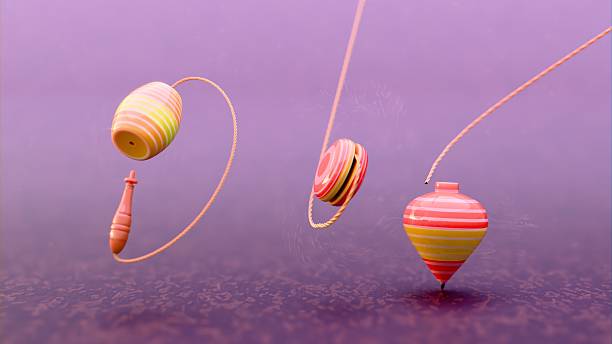 istock Three striped spinning tops standing upright on textured surface, aligned diagonally, showing traditional toy design used in physical coordination games and classic childhood activities. 2210101428