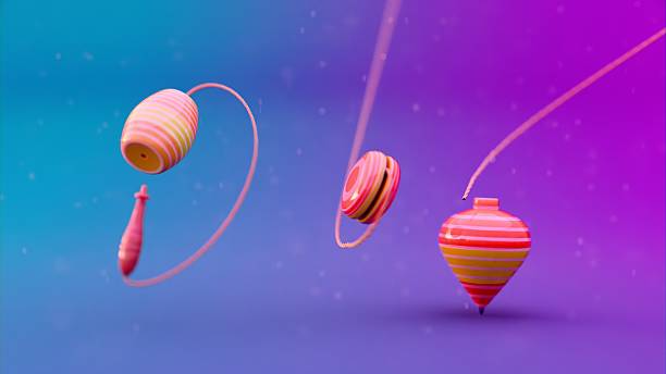 istock Fantasy background with three striped spinning tops standing upright on textured surface, aligned diagonally, showing traditional toy design used in physical coordination games and classic childhood activities. 2210101439