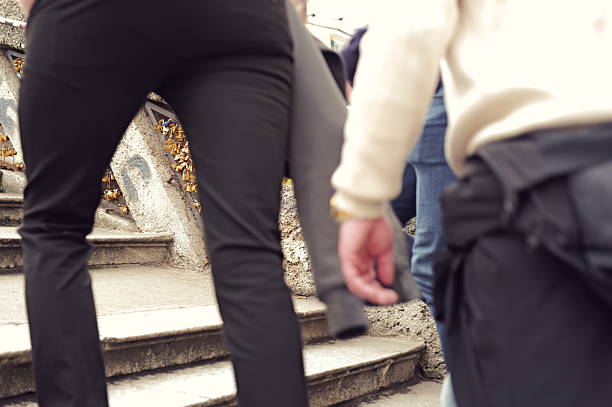Two cheerful businesswomen are walking down the stairs in New York City, enjoying a coffee break and sharing a laugh