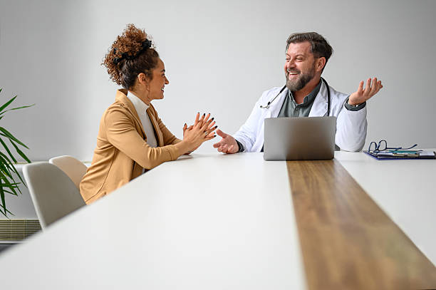 istock Happy male doctor talking with woman while explaining her electronic medical record over laptop in clinic 2210107025