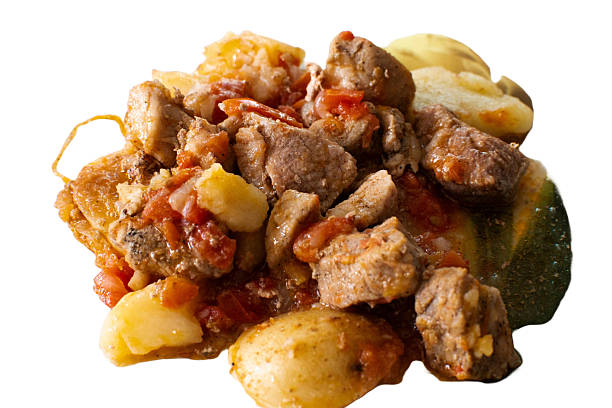 A close-up of a hearty stew featuring tender chunks of meat, soft potatoes, and rich tomato pieces, cooked to perfection. The dish exudes warmth and comfort, capturing the essence of home-cooked meals.
