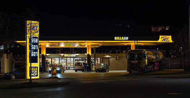 Twilight drone photo of MOYA service station, radiant blue-red canopy, clean forecourt illumination, architectural lines, great for retail, energy, travel, commercial ads.