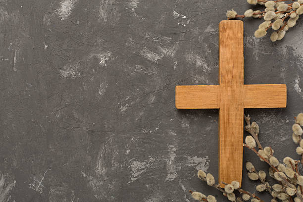 Cross with willow branches on concrete background, top, view. Palm Sunday concept