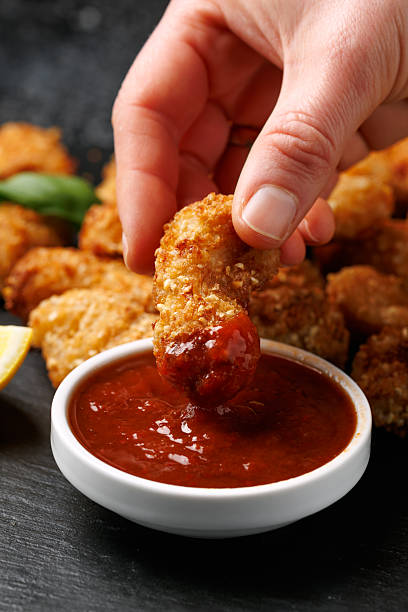 istock Crispy breaded scampi nuggets with sauce on stone board 2210112314