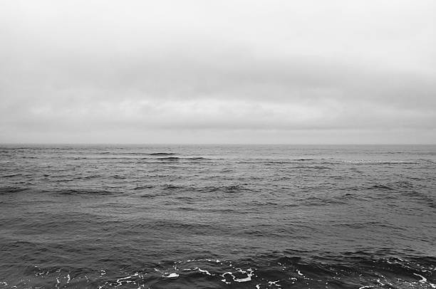 istock Dramatic cloudy mist sky over dark wave sea 2210116798