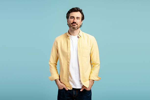istock Confident entrepreneur posing with hands in pockets on blue background 2210117551