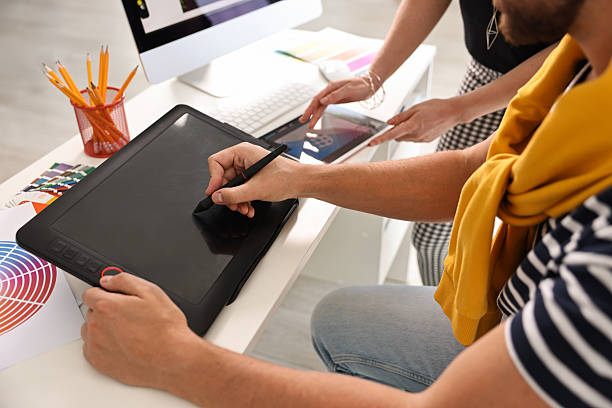 istock Designers working together with tablets at table in office, closeup 2210122910