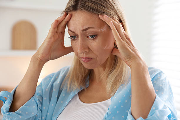 istock Menopause. Woman suffering from headache at home 2210129573