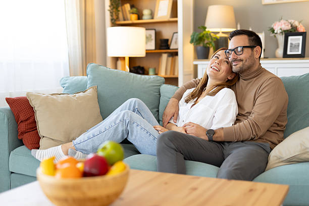 istock Happy Couple Relaxing and Embracing Each Other on Sofa 2210130668