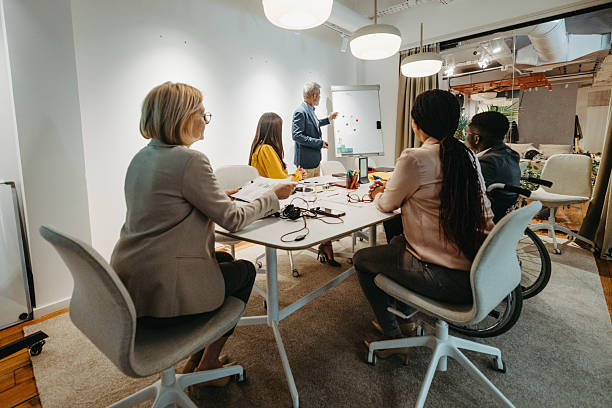 istock Mature businessman leading team meeting using whiteboard 2210134585
