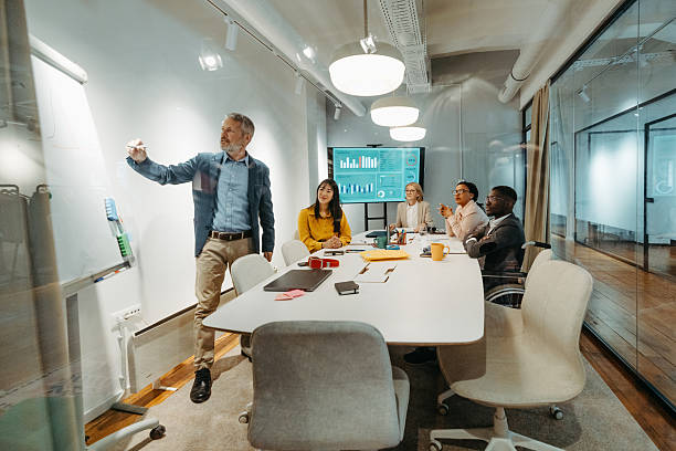Senior executive conducting strategy session with whiteboard