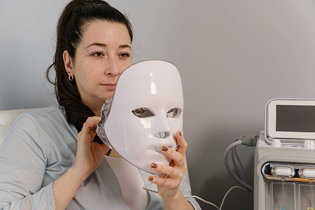 istock Female doing skincare with LED red light mask at home 2210134626