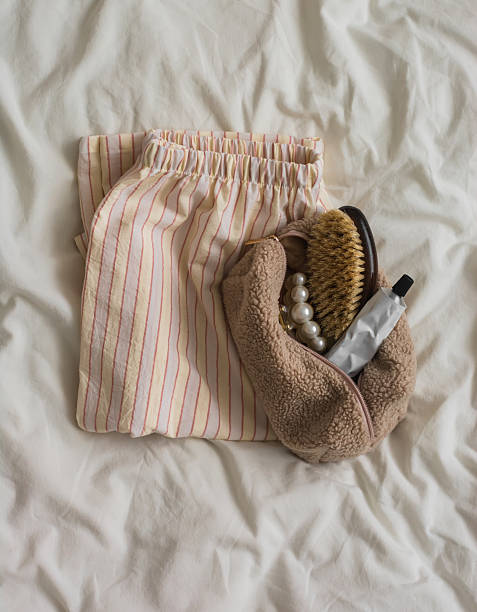 istock Pajama pants, makeup bag, comb, cream, hair clip on a light background, top view 2210141009