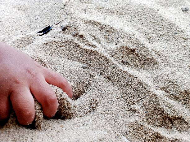 Children are playing in the sand on the beach