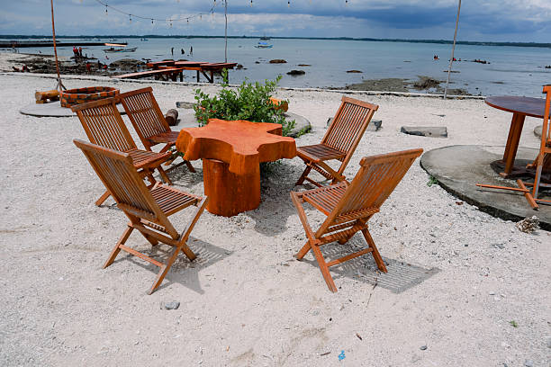 A tranquil beach scene with inviting wooden chairs and a unique star-shaped table.