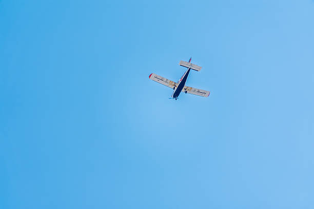 istock Small ultralight airplane with overhead wing and single propeller flying in sunset sky. 2210151102