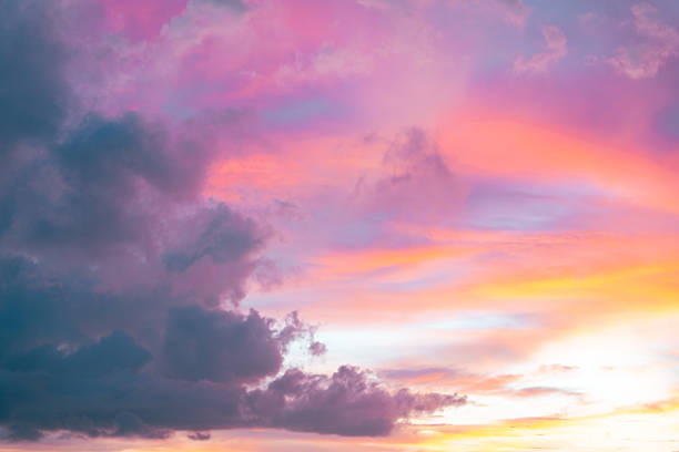 istock Evening sky glows with fiery orange and soft pink clouds, melting into deep blue twilight 2210155618