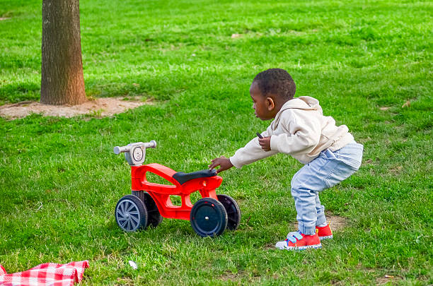 istock Little boy playing with red toy motorcycle in park 2210156632