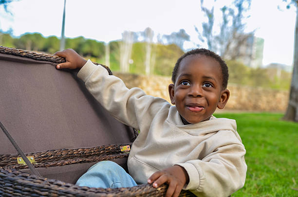 istock Curious child exploring a wicker basket in a park: discovering hidden treasures 2210157275