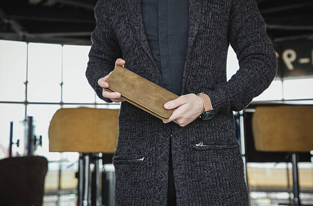 istock male holding brown wallet in urban setting 2210157494