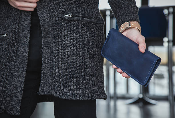 Male hand holding blue wallet in office setting