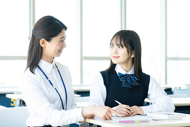 female student and teacher studying - 覚える ストックフォトと画像