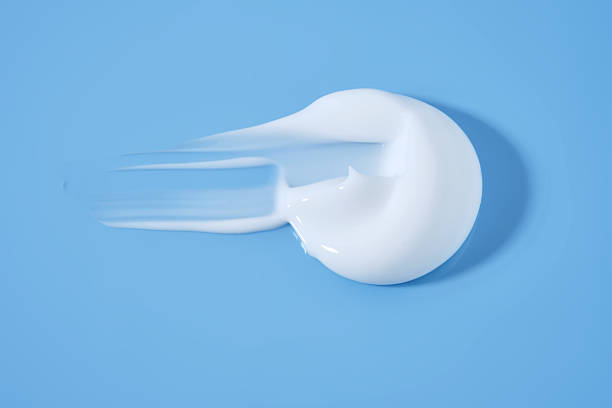 istock A smear of white cream on a blue background. 2210161963