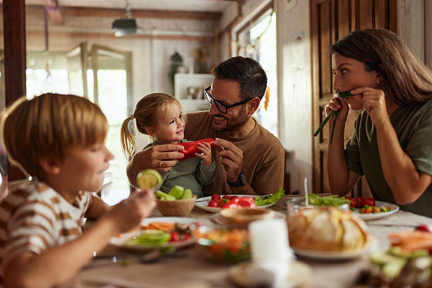 istock Playful family having fun during a meal at dining table. 2210162048