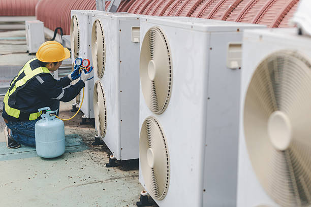 istock Technician is checking air conditioner. Air conditioning, HVAC service technician using gauges to check refrigerant and add refrigerant. 2210162846