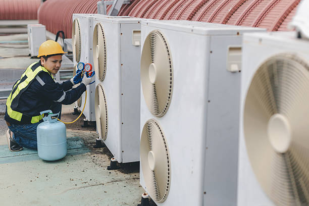 istock Technician is checking air conditioner. Air conditioning, HVAC service technician using gauges to check refrigerant and add refrigerant. 2210162864