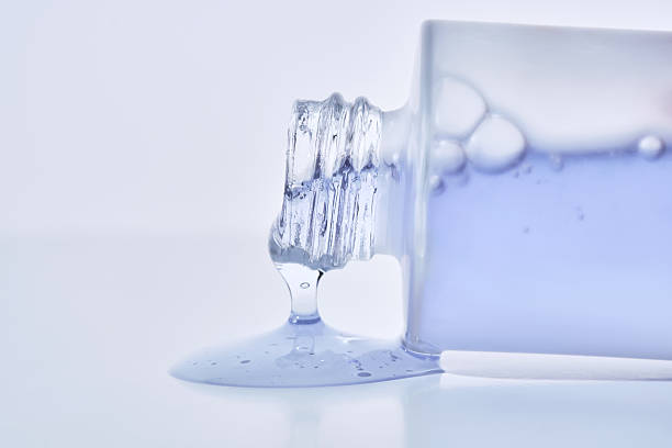 istock A cosmetic bottle from which a blue emulsion is poured. 2210163733