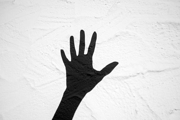 Black shadow of a hand against a white background.