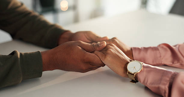 istock Holding hands, empathy and couple in home for love, compassion and communication on table. Relationship, dating and closeup of man and woman with affection or gesture for commitment, trust or support 2210167233
