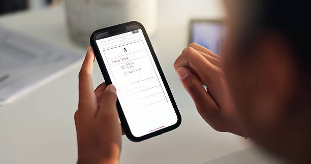 istock Hands, phone screen and person with flight booking for trip planning, ticket information or holiday destination. Closeup display, smartphone or travel agency webpage for vacation or New York location 2210167354