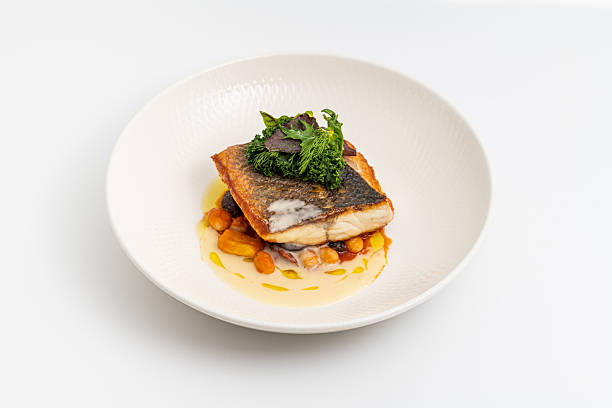 istock Crispy-skinned pan-seared fish fillet with chickpeas, creamy sauce, and fresh greens 2210168532