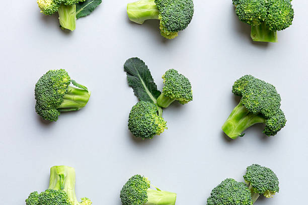 istock green fresh broccoli background close up on colored table. Vegetables for diet and healthy eating. Organic food 2210168869